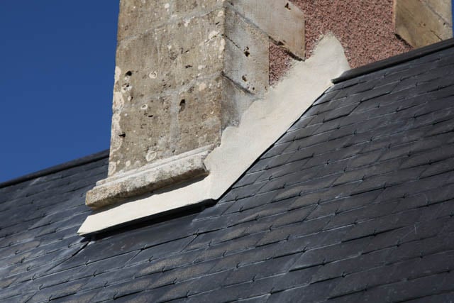 Rénovation de la couverture du château abritant les services administratifs et de direction du lycée agricole Le Robillard. Détail du raccord maçonné avec une souche de cheminée qui ont été bouchées par l'ajout d'un éléments en zinc.