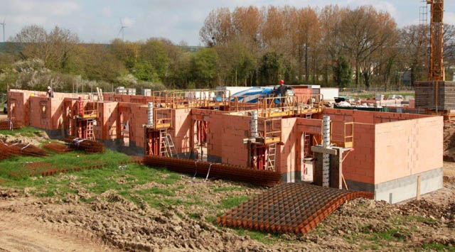 Construction d'une maison de santé à Aunay sur Odon (14). Trois bâtiements réalisée en briques monomur montées sur un soubassement en agglos bancheurs et couvert par un toit plat réalisé en prédalle.